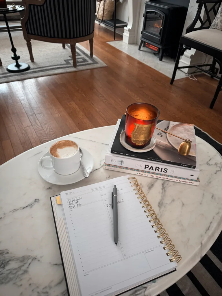Candle and planner on a coffee table.