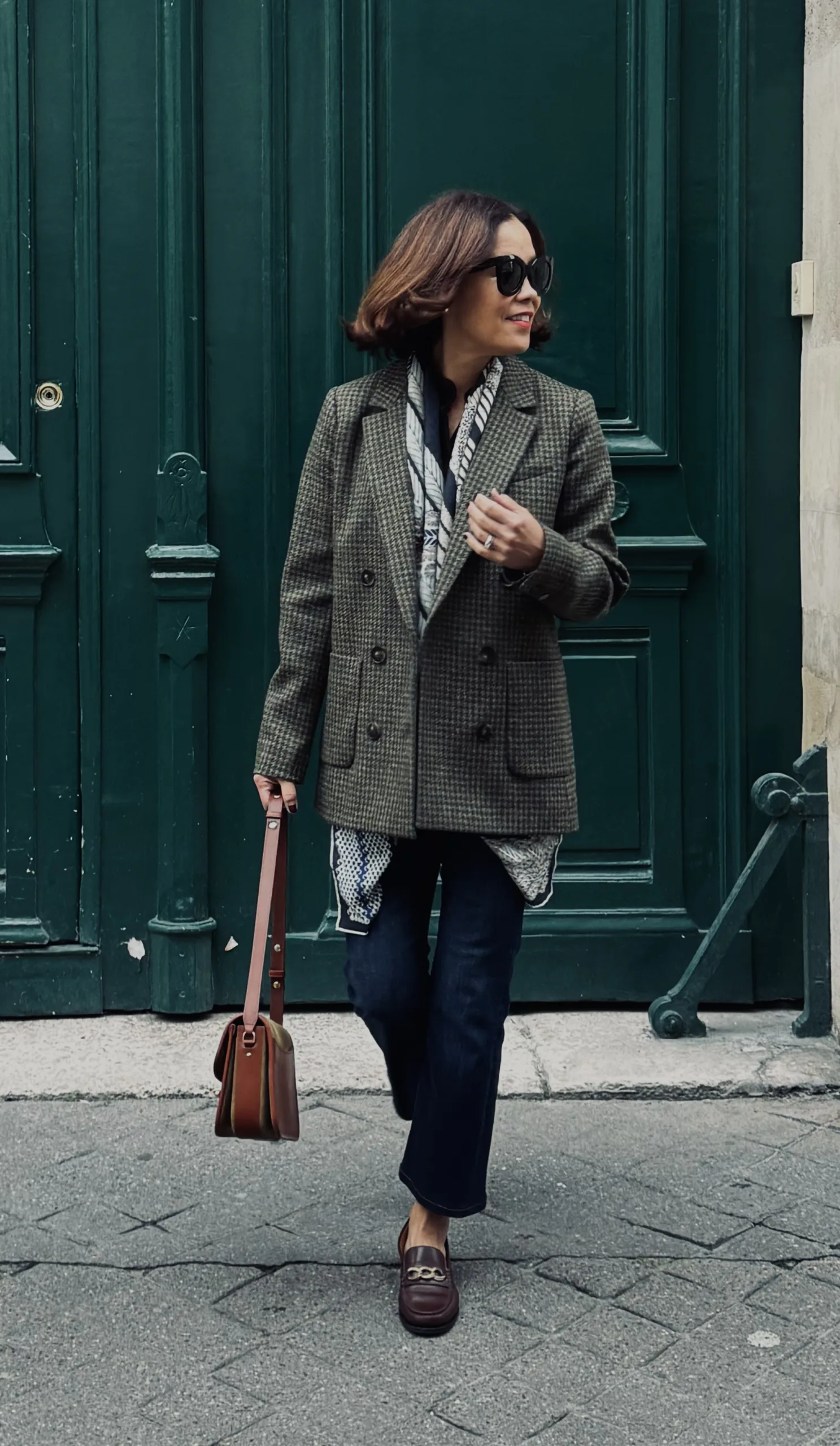 Woman wearing blazer with denim and bag.