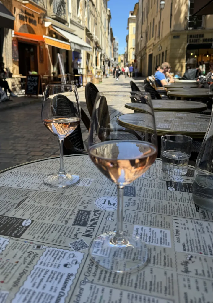 Two wine glasses with Rose sitting on a table.
