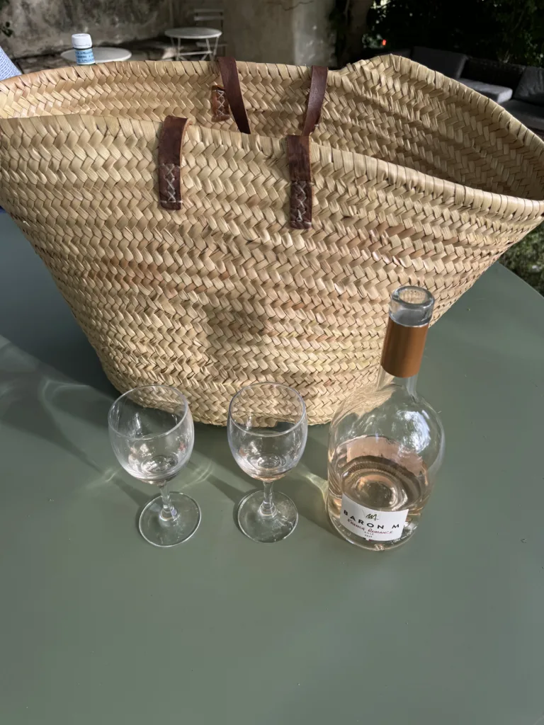 Basket bag on a table with two wine glasses and bottle of Rose