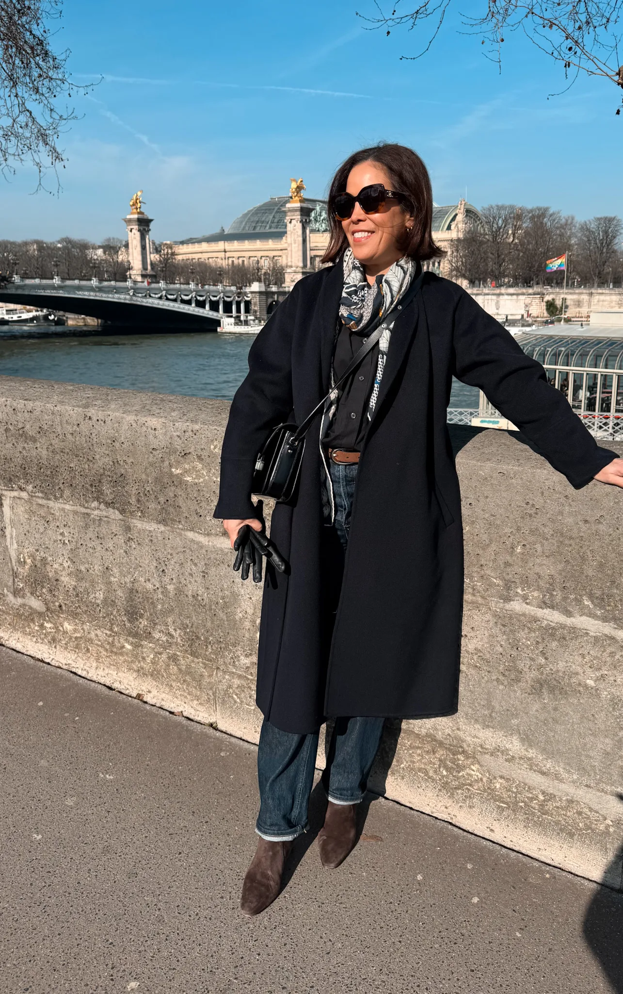 Woman wearing wool coat wearing jeans and boots.