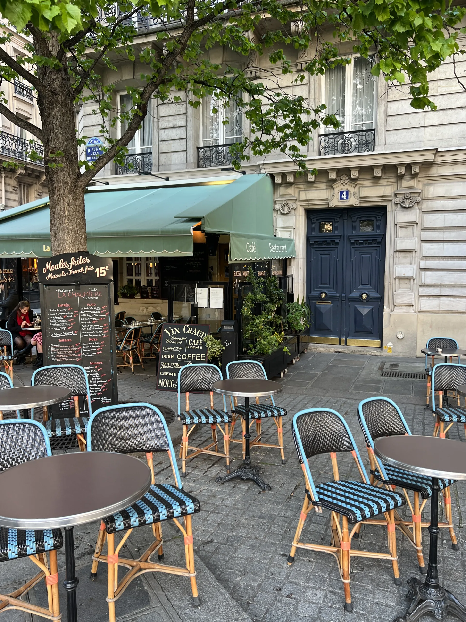 blue cafe chairs in front of a blue door in Paris.