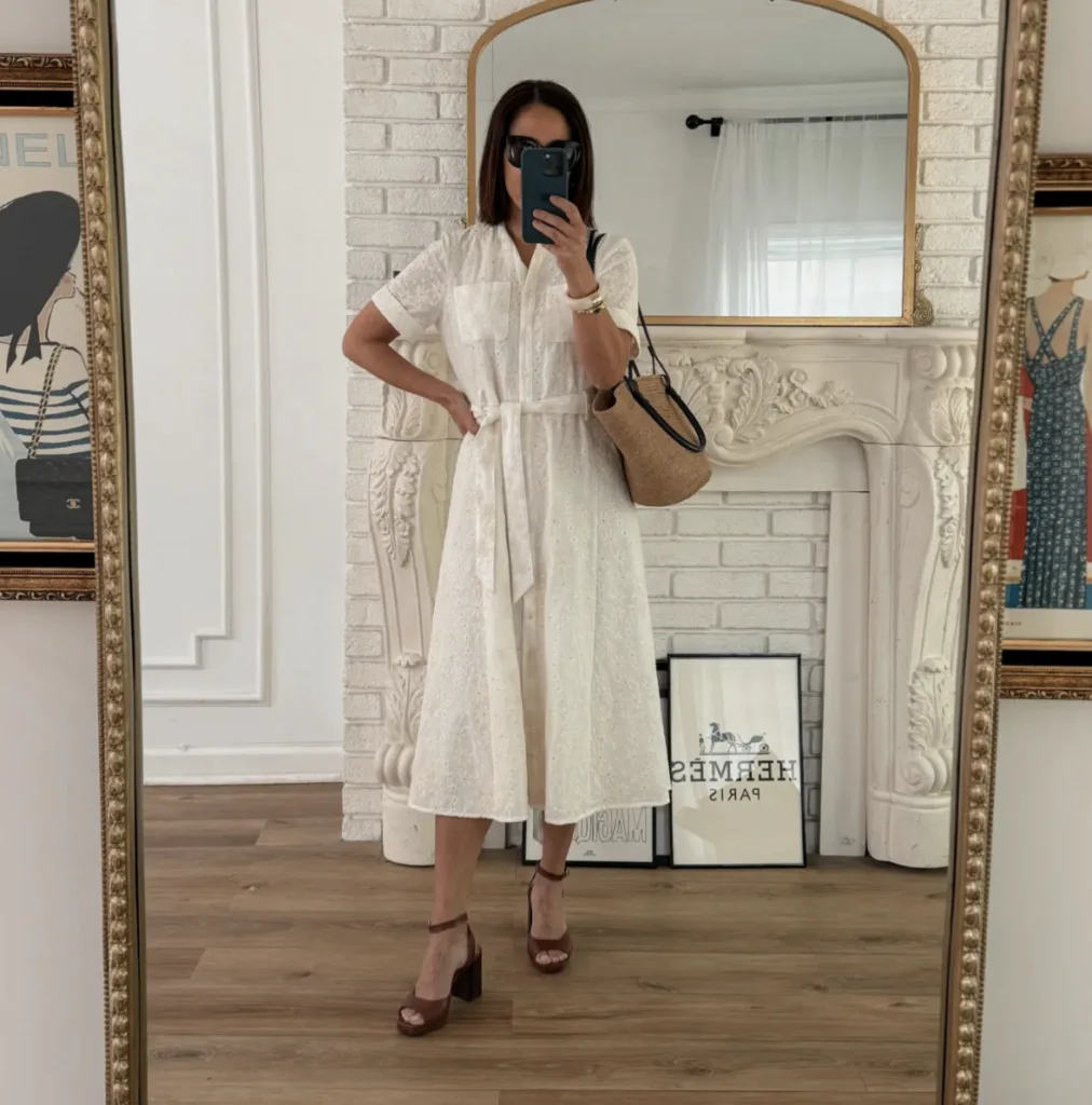 Woman wearing the Sezane Adelle Dress looking into a mirror.