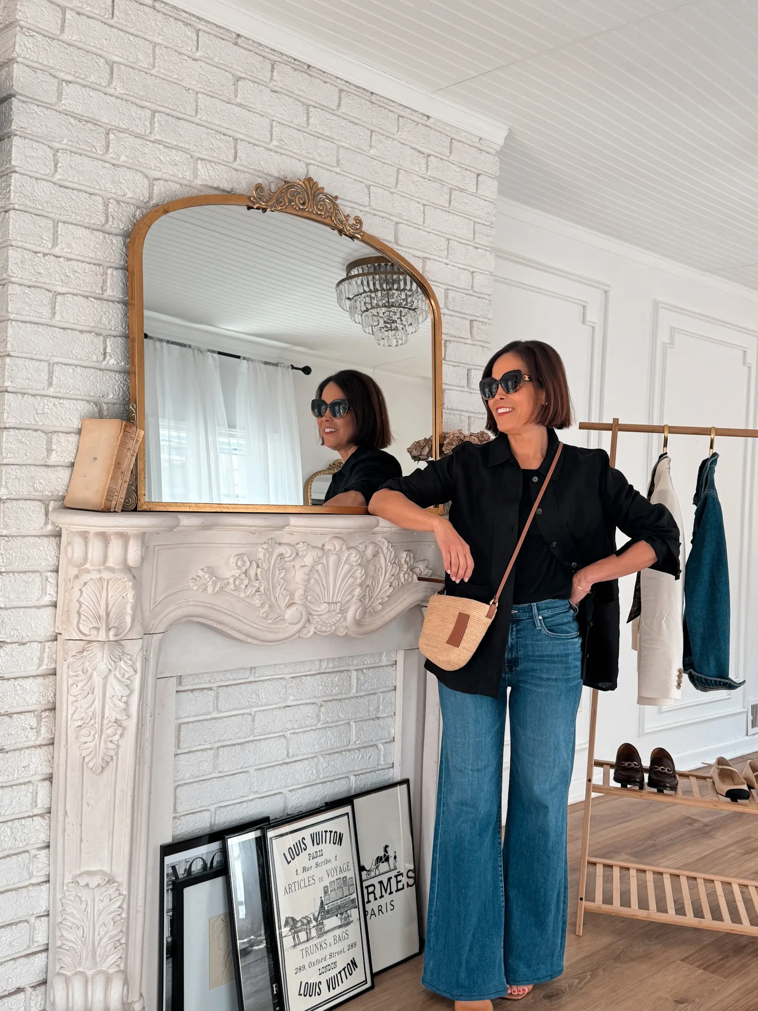 Woman wearing black linen jacket with denim and sandals.