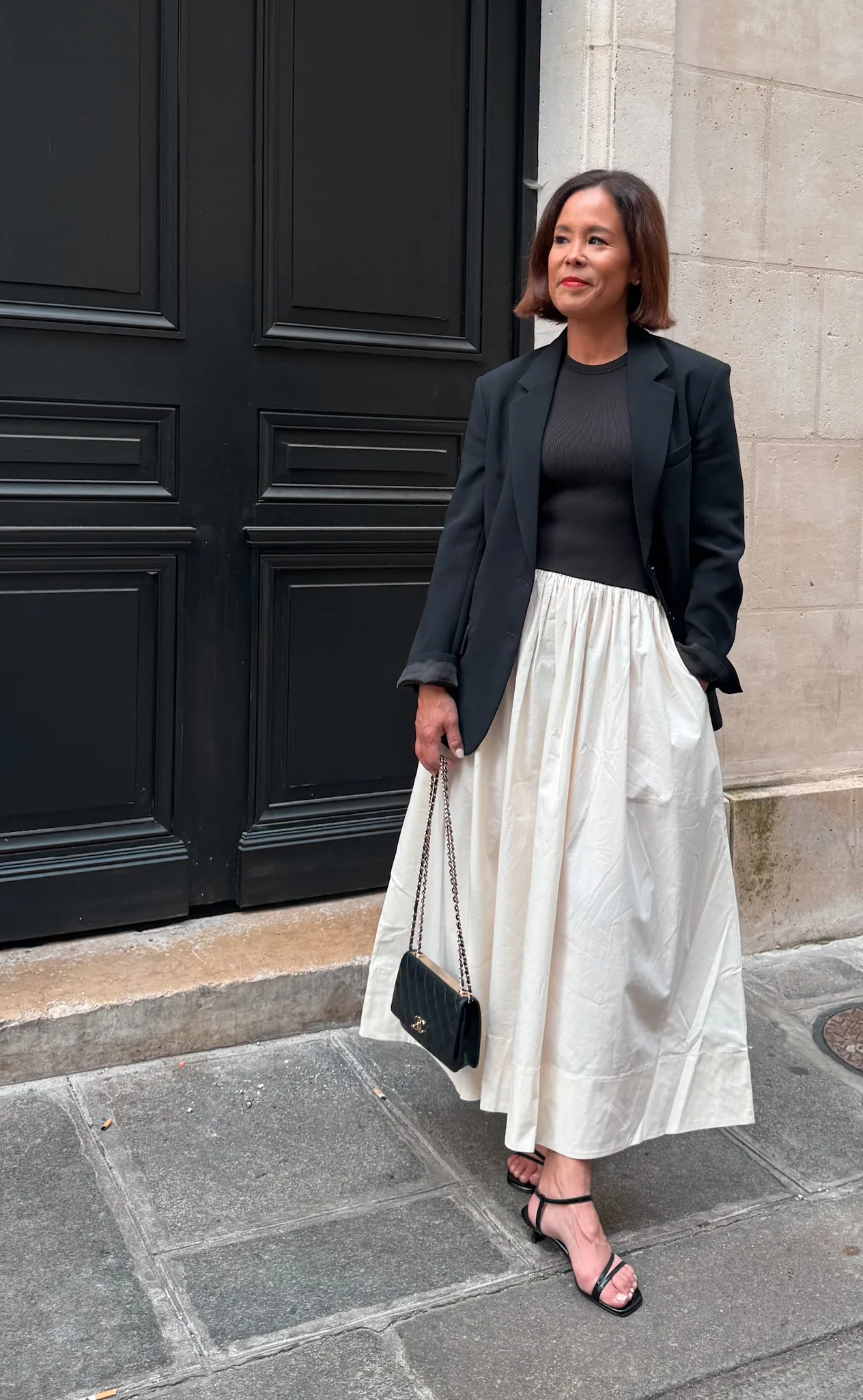 Woman in black and white dress with black sandals.