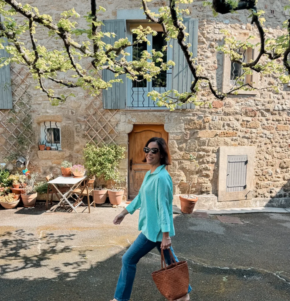 Woman wearing striped shirt, denim, and sandals.