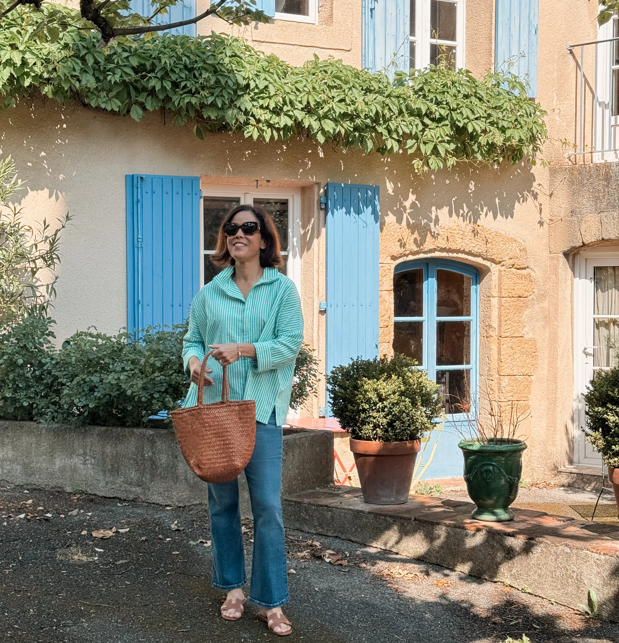 WOMAN IN STRIPE TOP WITH DENIM AND SANDALS.
