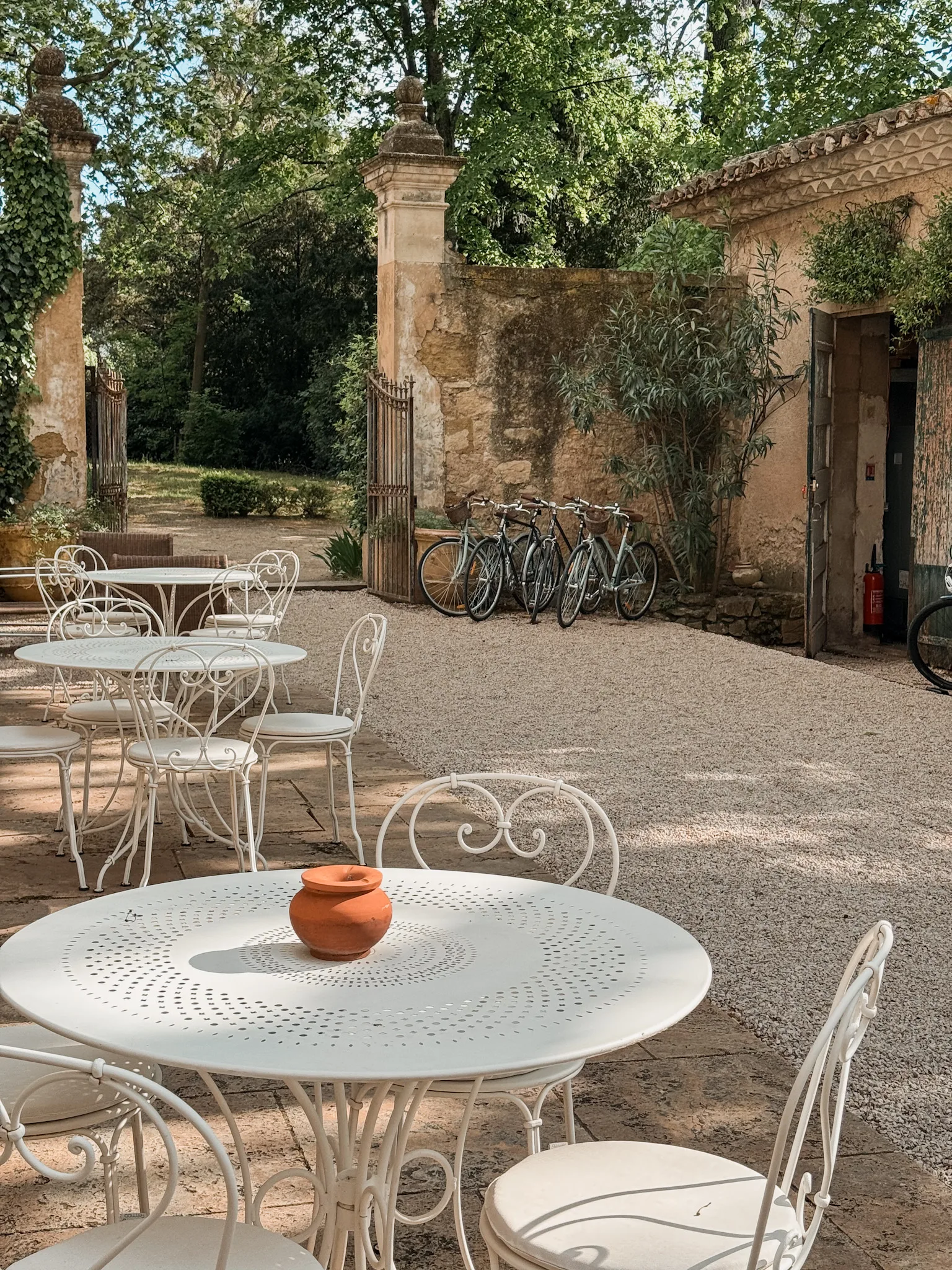 Tables and chairs in Provence surrounded by pea gravel. 