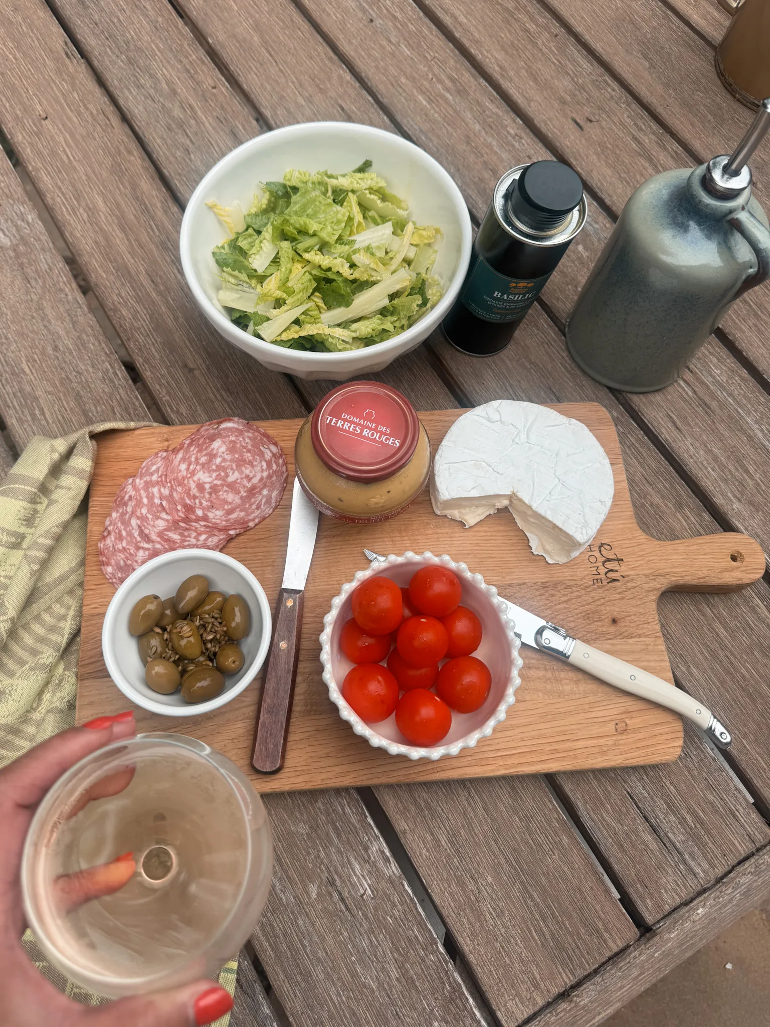 Table with tomatoes, cheese, olives, glass of wine.