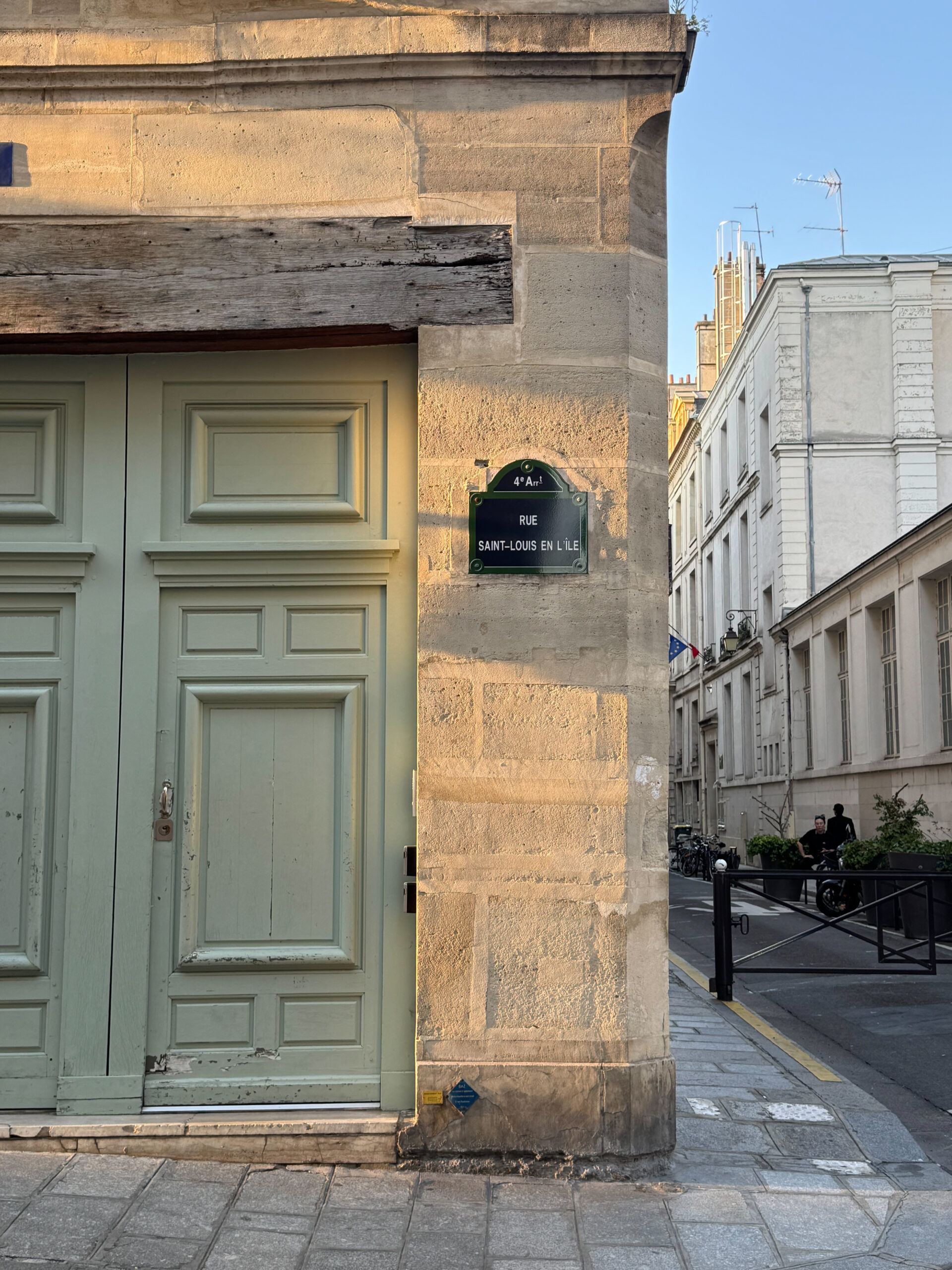 Green door and ile saint louis sign on a wall. 