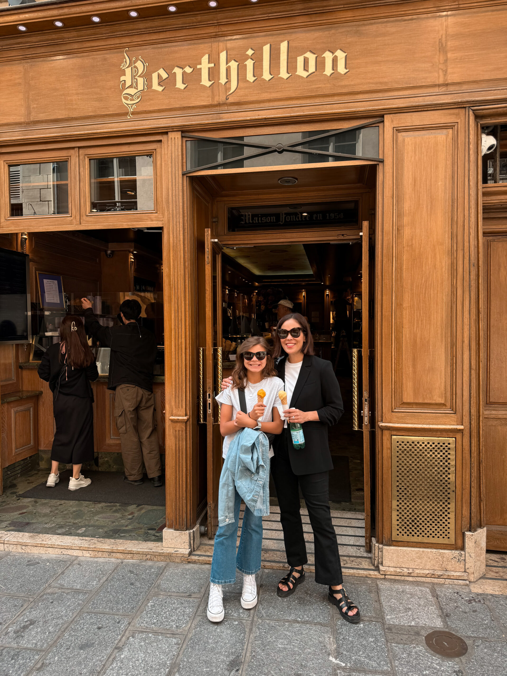 Woman and daughter standing in front of Berthillion ice cream in Paris on Île Saint Louis.
