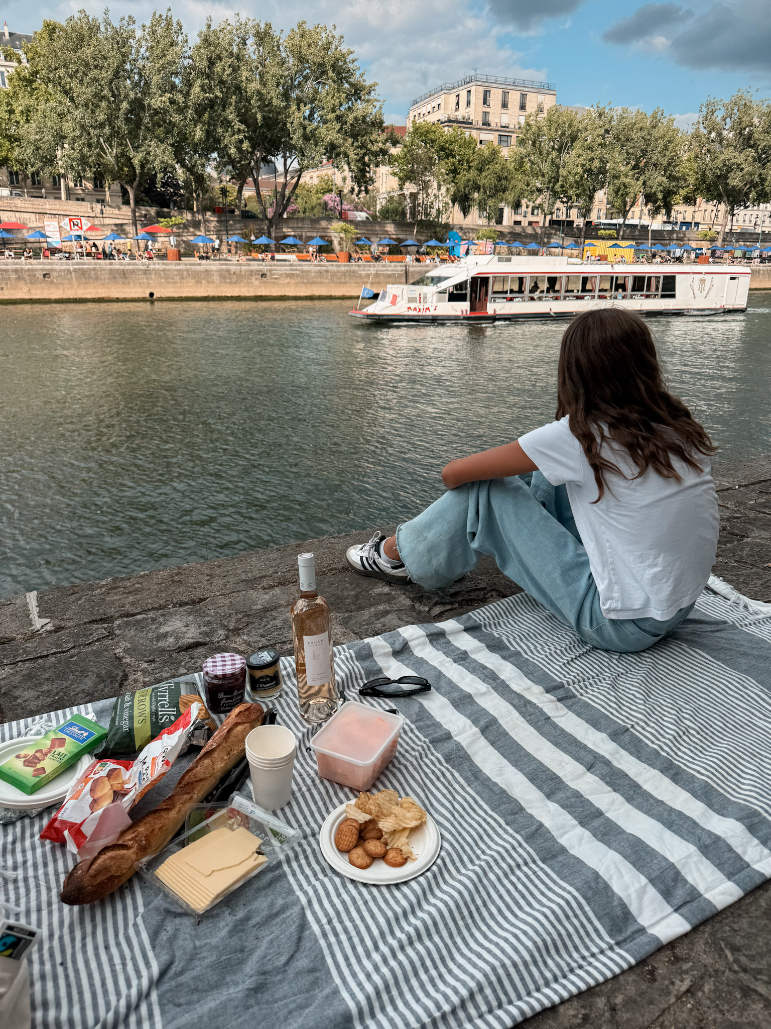 Little girl having a picnic by the Seine.