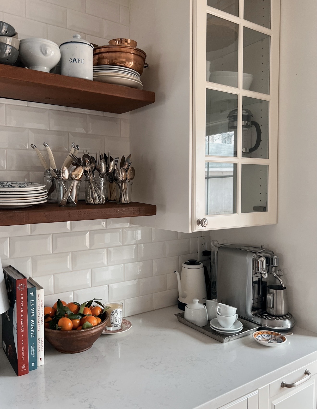 Interior shot of kitchen with shelves, bowl of oranges, and nespresso maker.