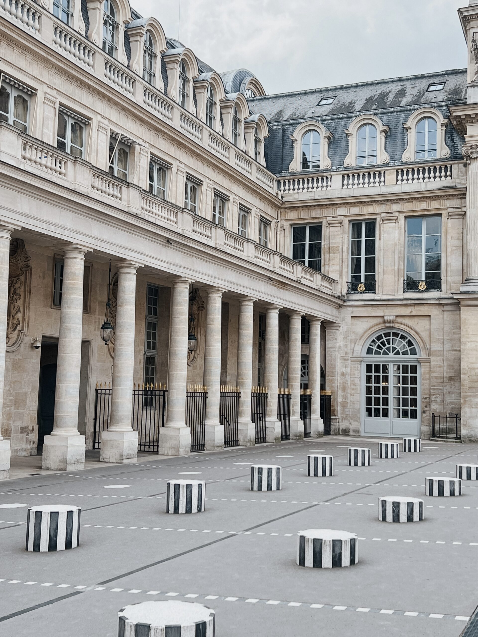 Palais Royal columns in Paris sharing what it looks like for a first time trip to Paris.