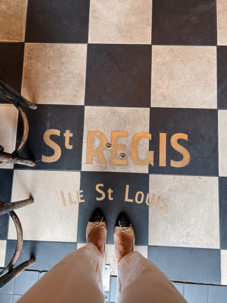 Ballet flats styled with neutral trousers inside a Paris café on Île Saint-Louis