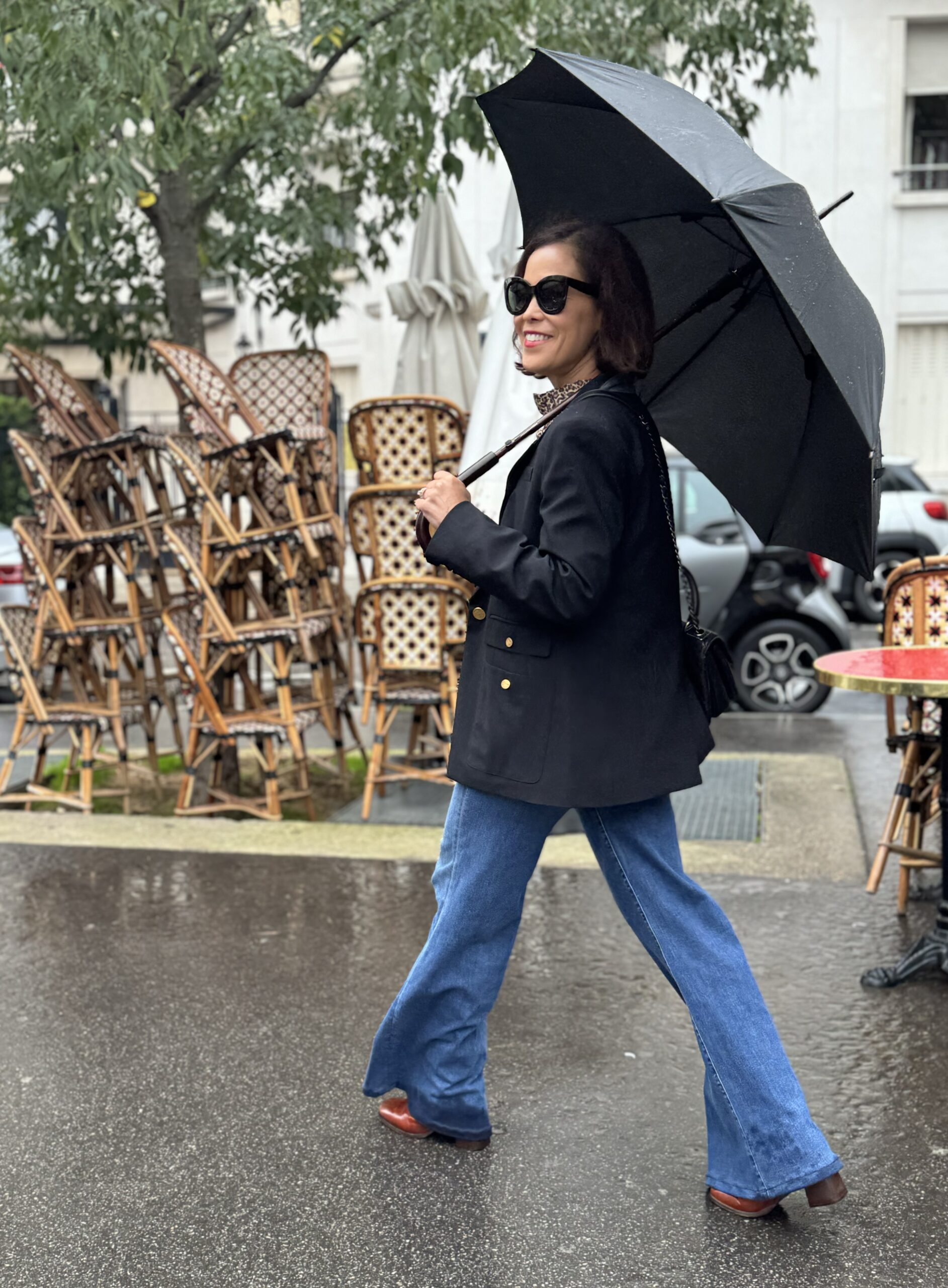 Paris weather in March on a rainy day: wearing a black blazer with jeans and carrying a travel umbrella for wet weather